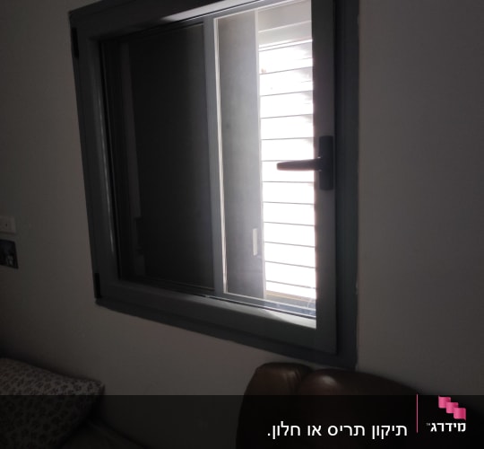 תריסים לבנים מאחורי חלון זכוכית כהה